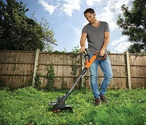 BLACK+DECKER STC1820PC-GB Cordless Grass Trimmer in use.