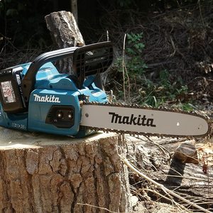 Makita DUC355Z Chainsaw sitting on a log.