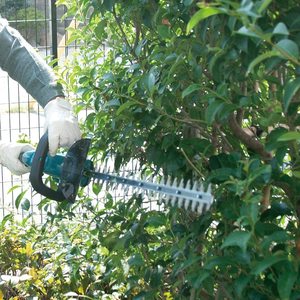 Makita DUH523Z Cordless Hedge Trimmer in use.