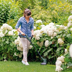 Bosch EasyGrassCut 18 Cordless Grass Trimmer in use.