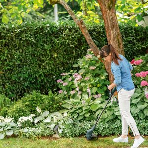 Bosch EasyGrassCut 23 Corded Grass Trimmer in use.